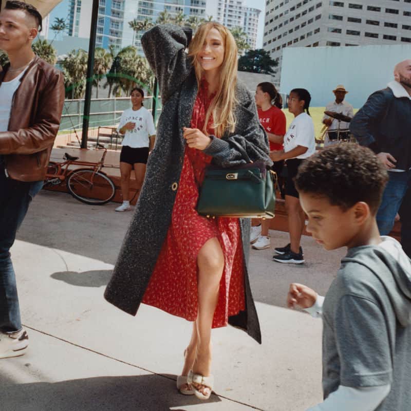 Elegant woman in red dress and coat at Victoria Leeds during fall 2021.