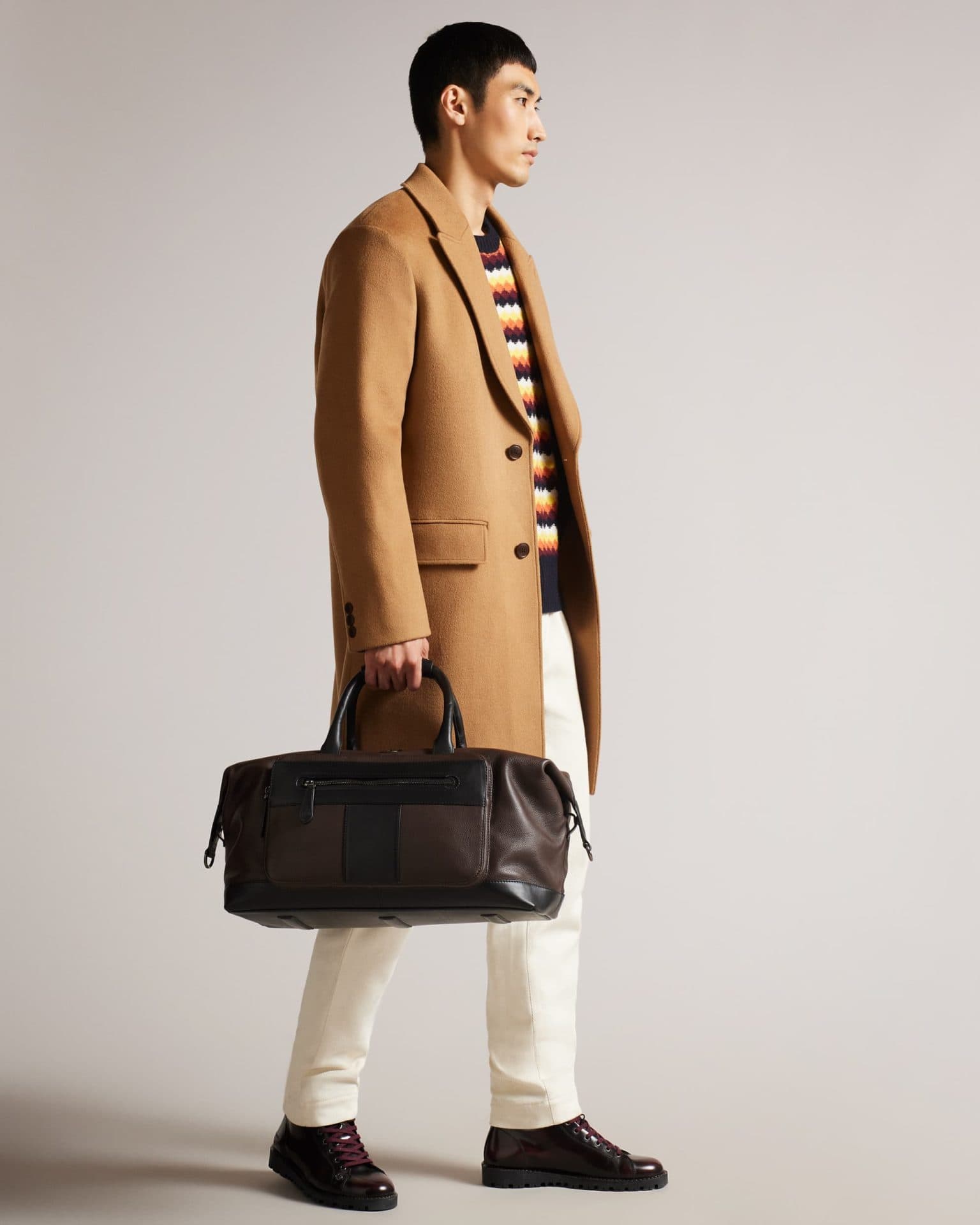 Stylish men's camel winter coat with a leather bag, perfect for Christmas gift ideas for him.