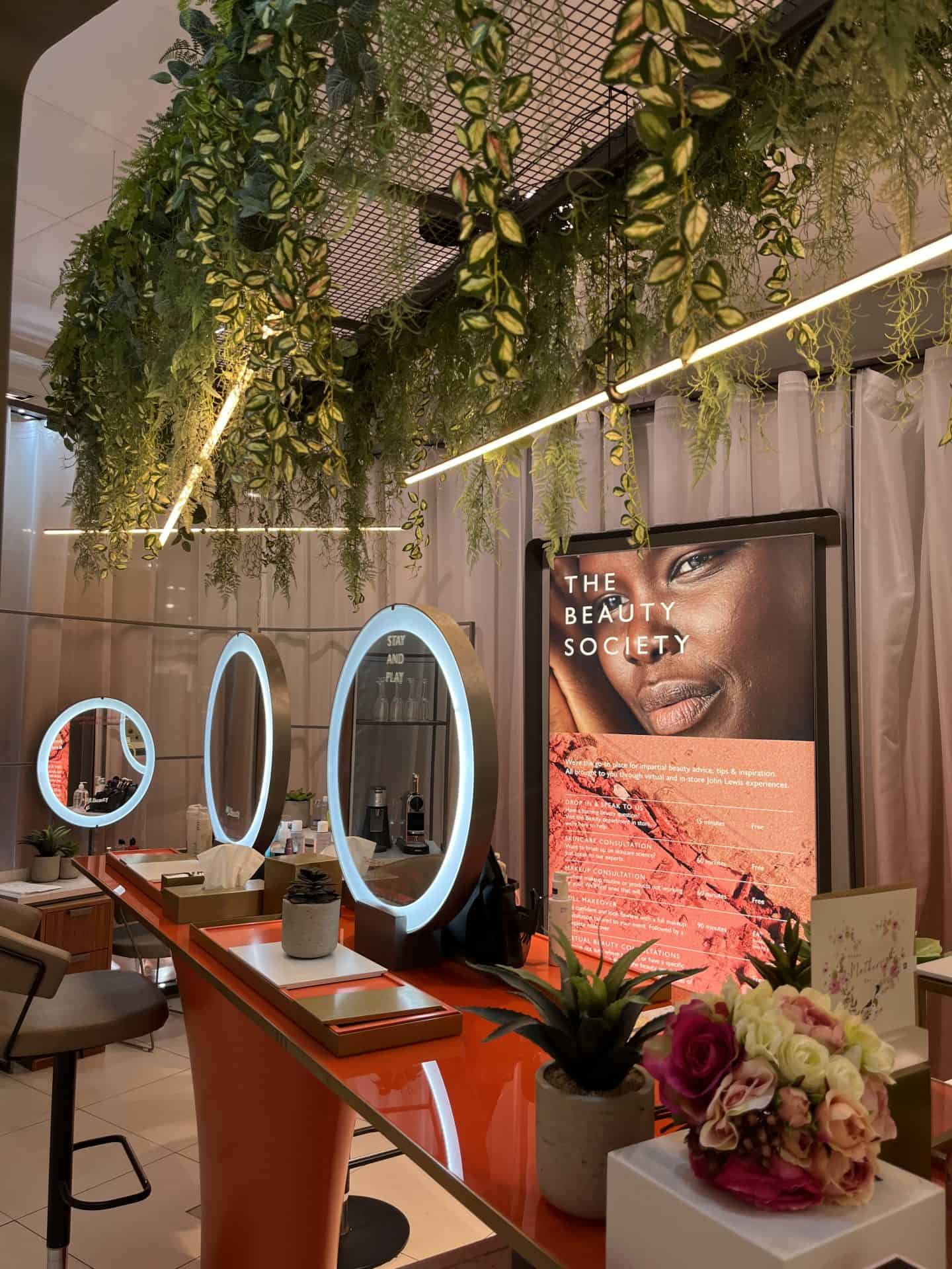 Makeup station at Victoria Leeds featuring illuminated mirrors and lush greenery.