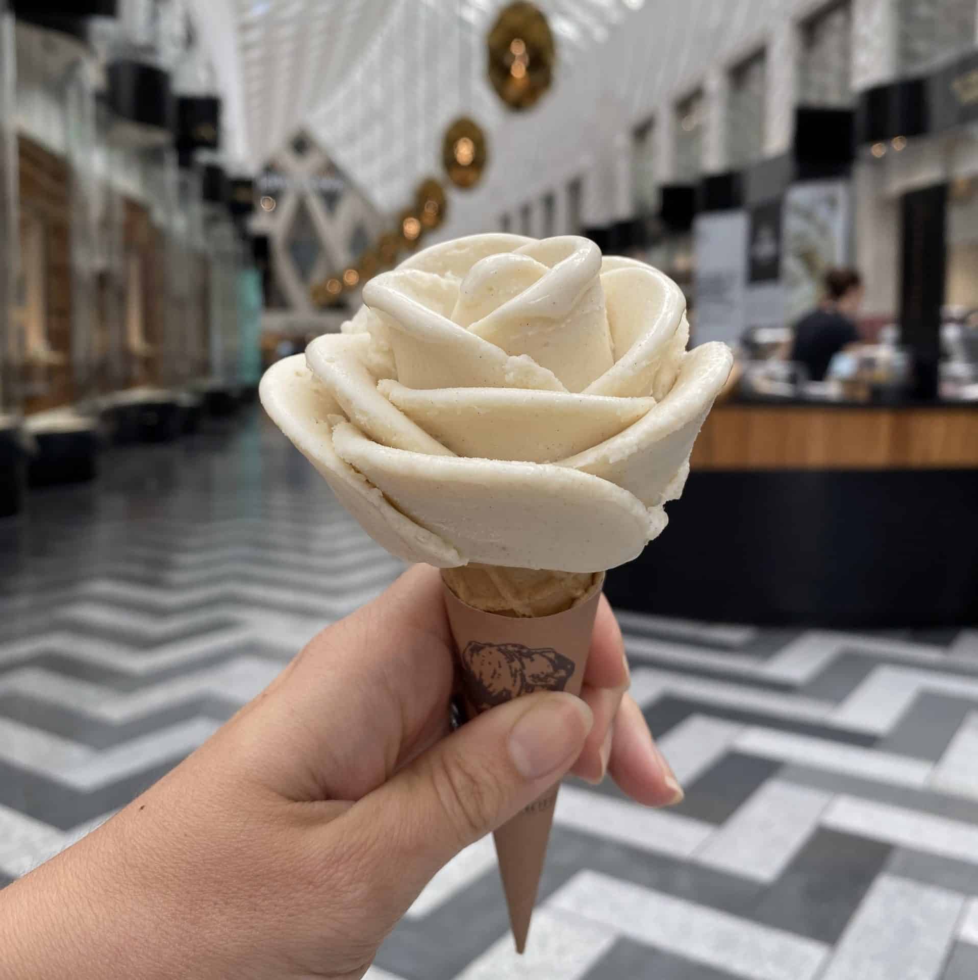 Delicious vanilla ice cream shaped like a rose held in a hand inside Victoria Leeds.