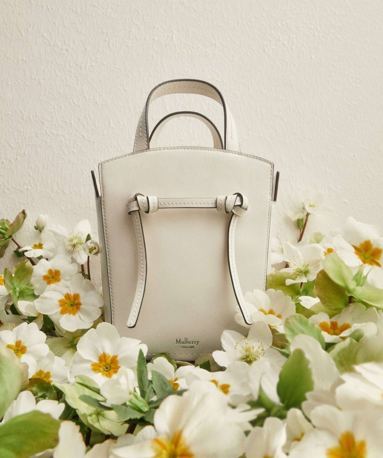 Elegant white handbag by Victoria Leeds, perfect for spring and floral occasions. Stylish accessory.