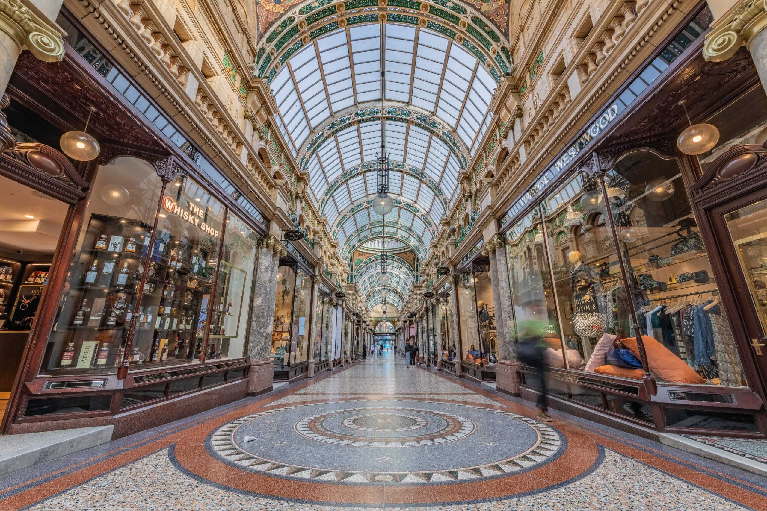 Elegant Victorian shopping arcade with glass roof and luxury boutiques in Leeds.
