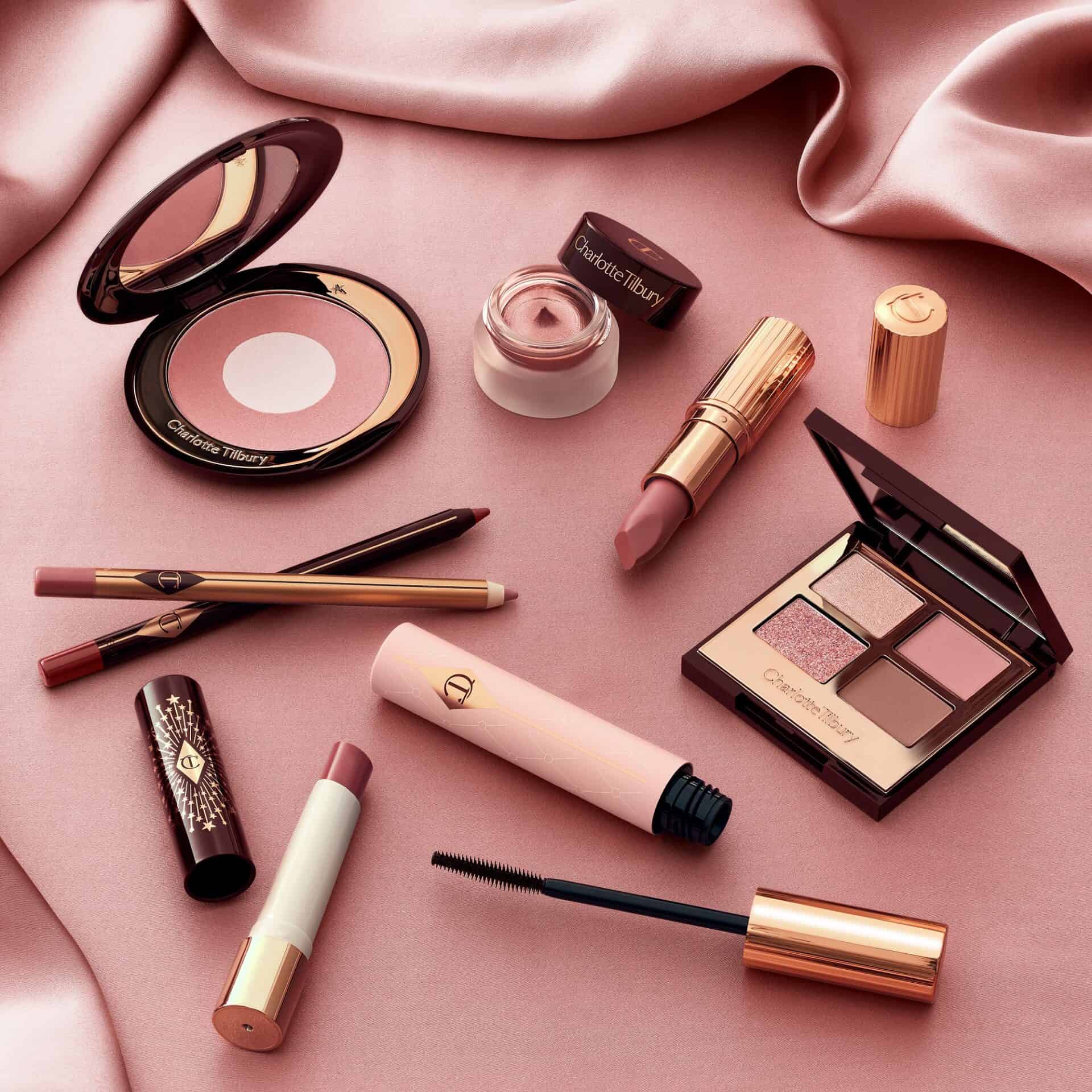 Victoria Leeds beauty brunches with Charlotte Tilbury makeup products on pink satin background.