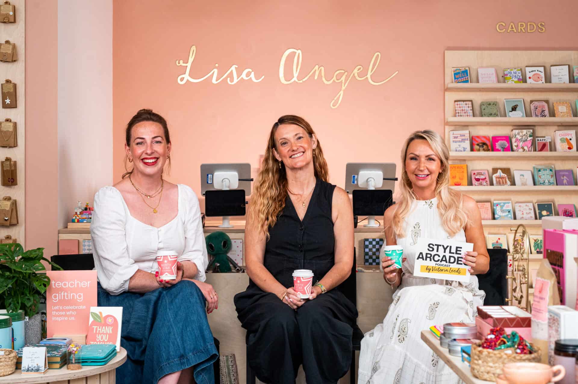 Three women at Victoria Leeds holding gifts and products in a boutique setting.