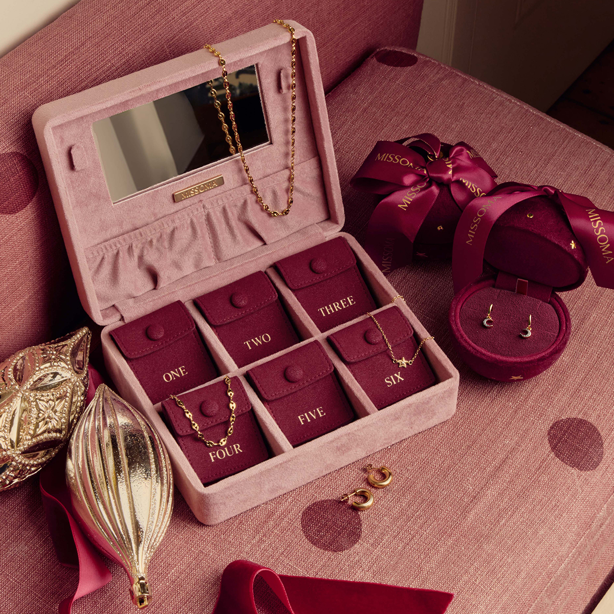 Luxury jewellery gift set with necklaces and earrings in pink velvet box.
