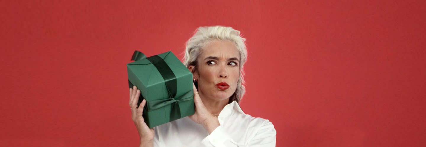 Woman holding a green Christmas gift box at Victoria Leeds shopping mall.