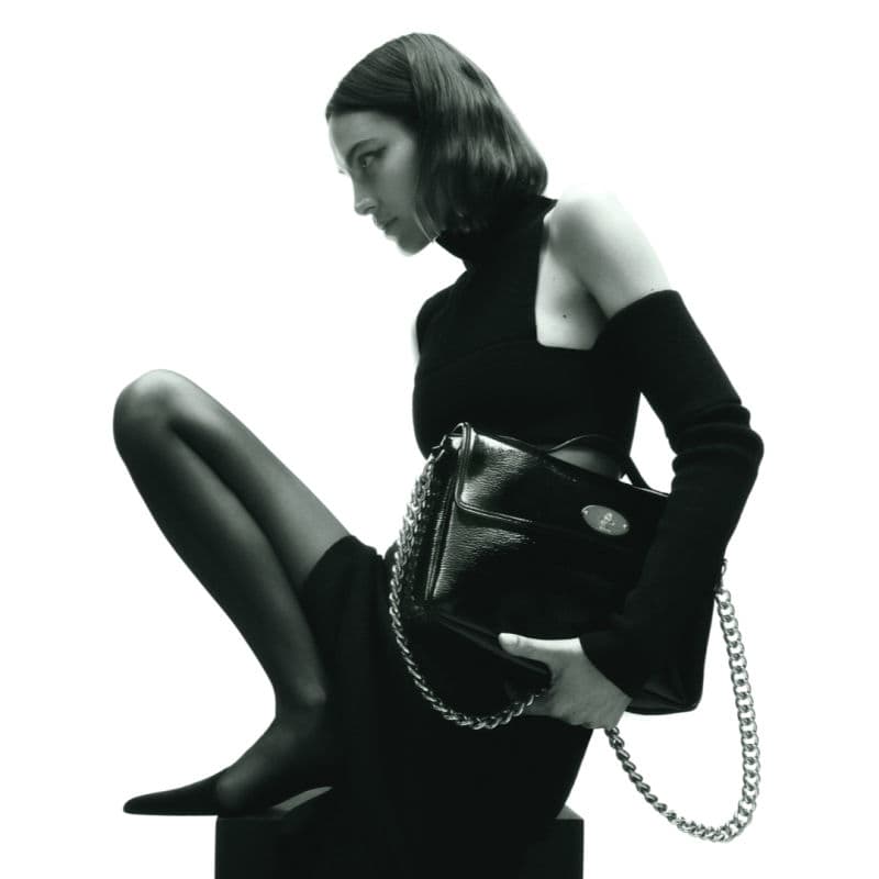 Elegant black outfit with Mulberry handbag and chain detail.