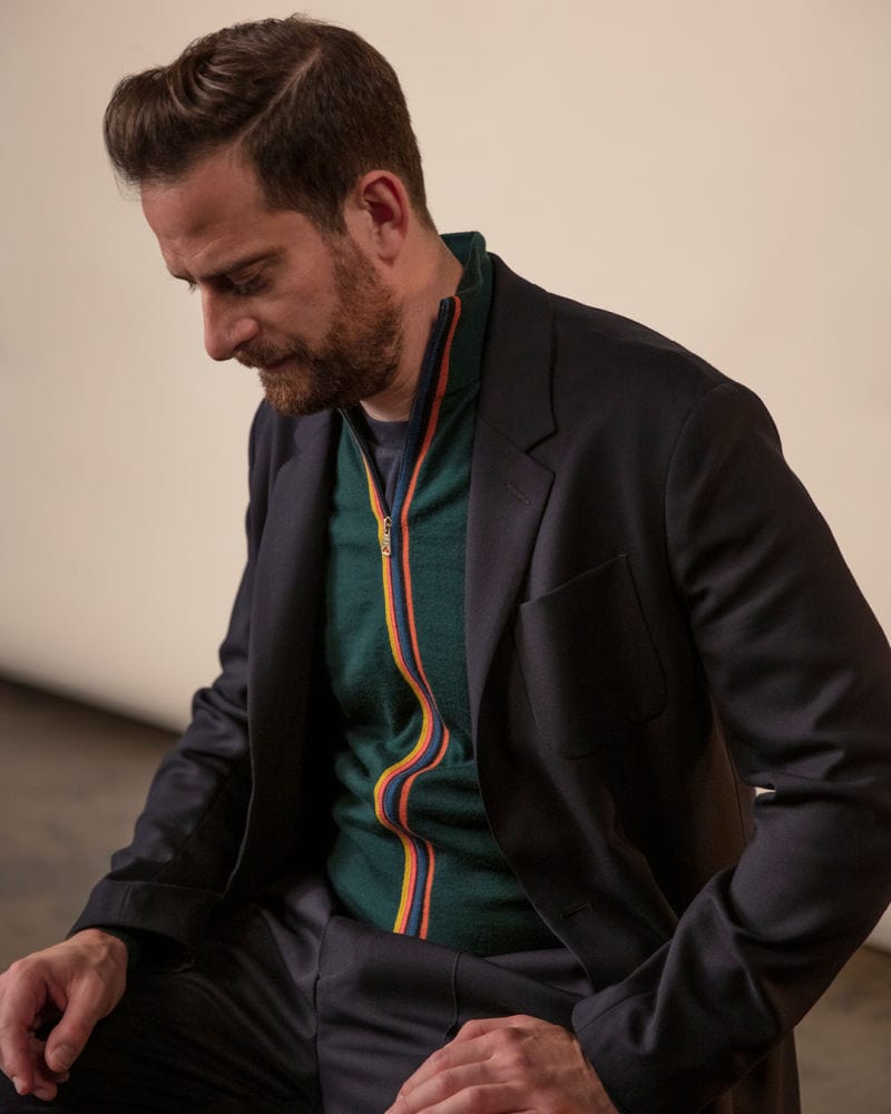 Stylish man in a blazer and colourful zip-up sweater at Victoria Leeds.