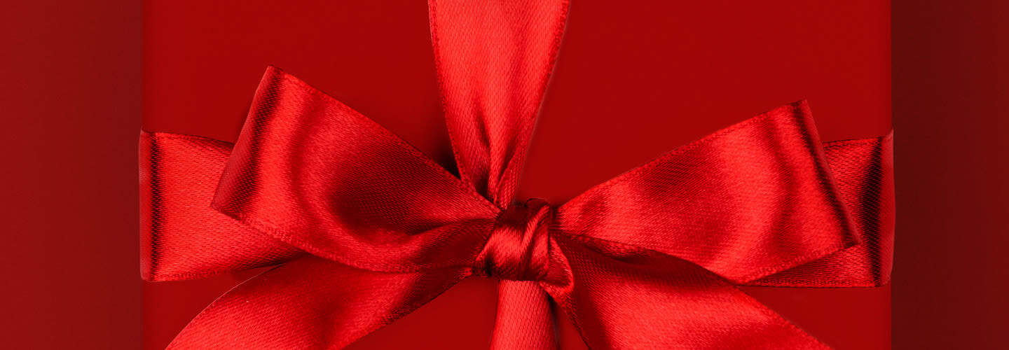 Red gift box with satin ribbon and bow, perfect for mindful gift ideas and special occasions.