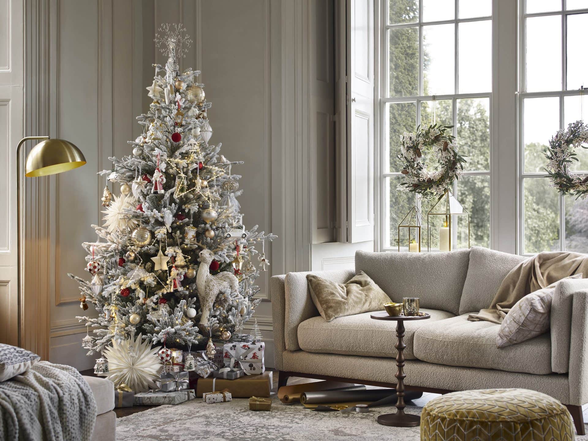 Christmas tree decorated with ornaments in a stylish living room setting.