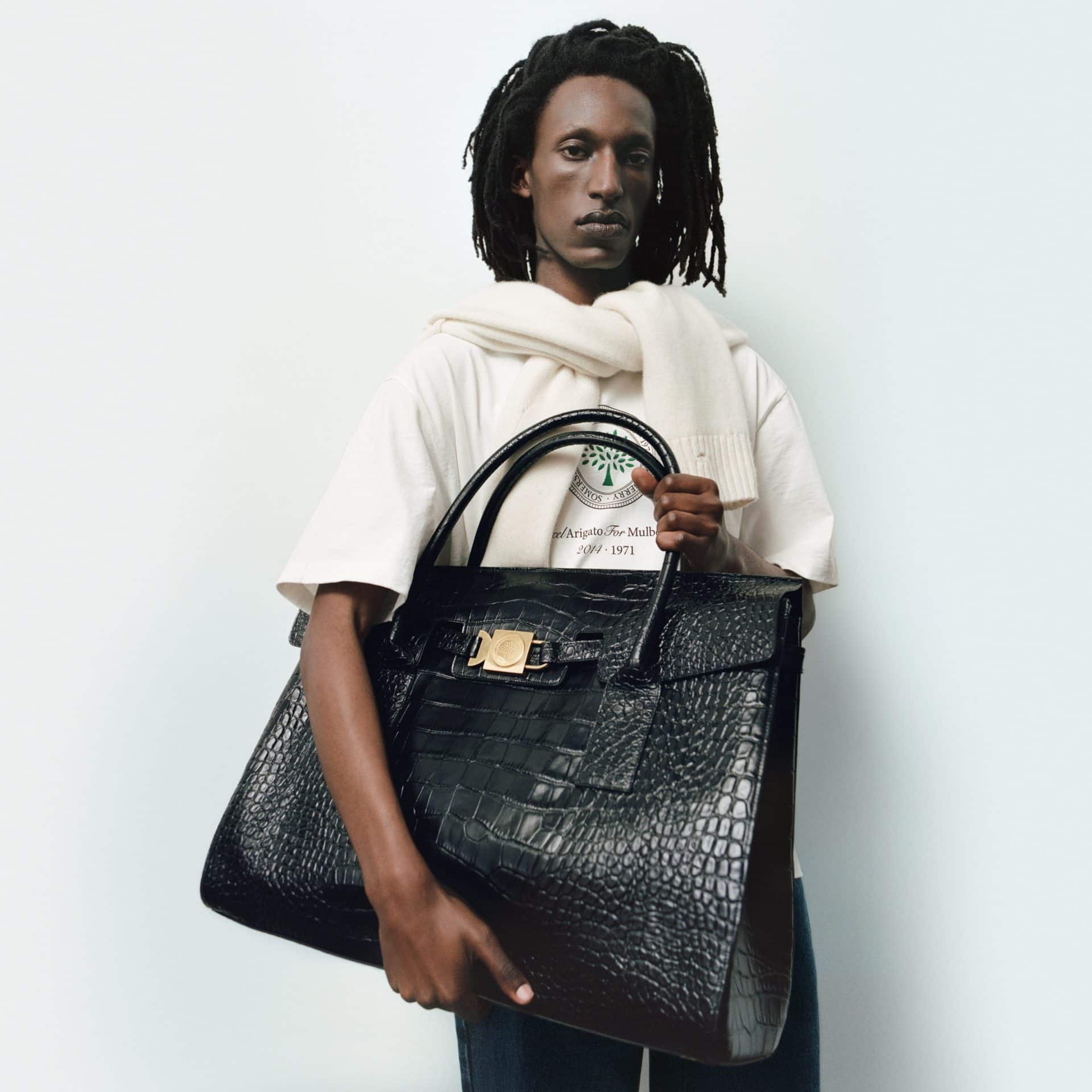 Fashion model holding a large black crocodile-embossed leather handbag at Victoria Leeds.