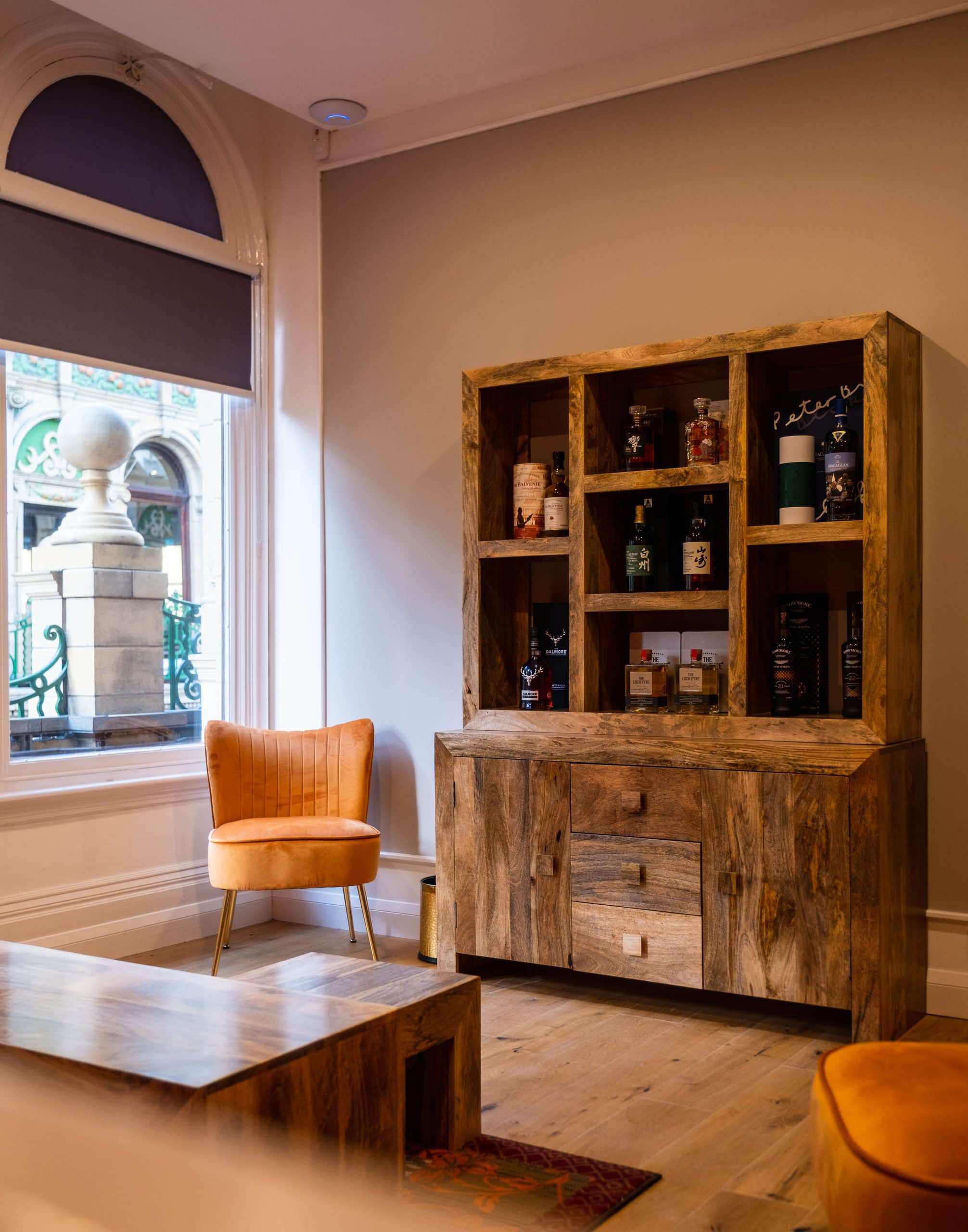 Vintage wooden whisky display cabinet with bottles and accessories.