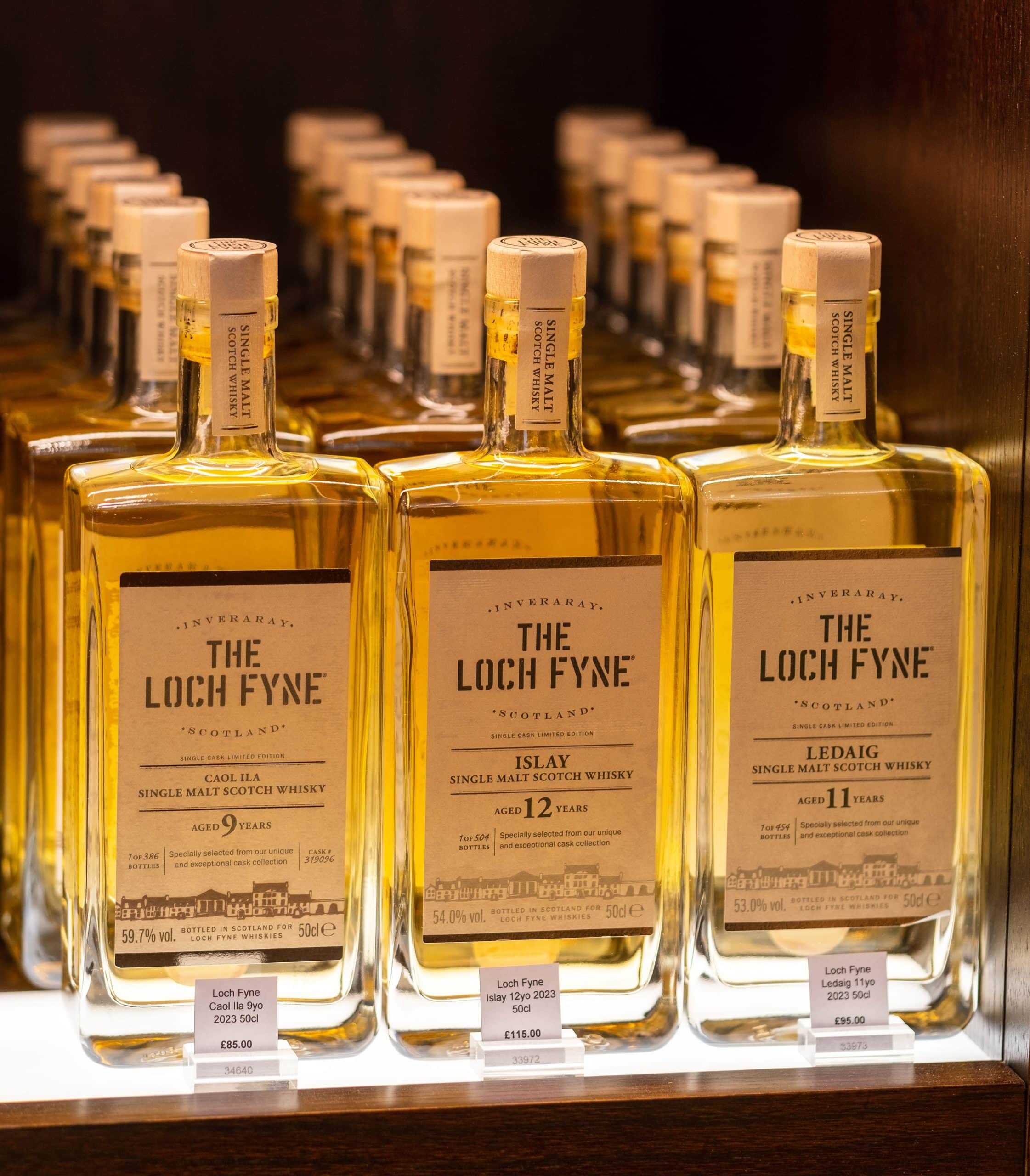 High-quality Scotch whisky bottles displayed on a store shelf.