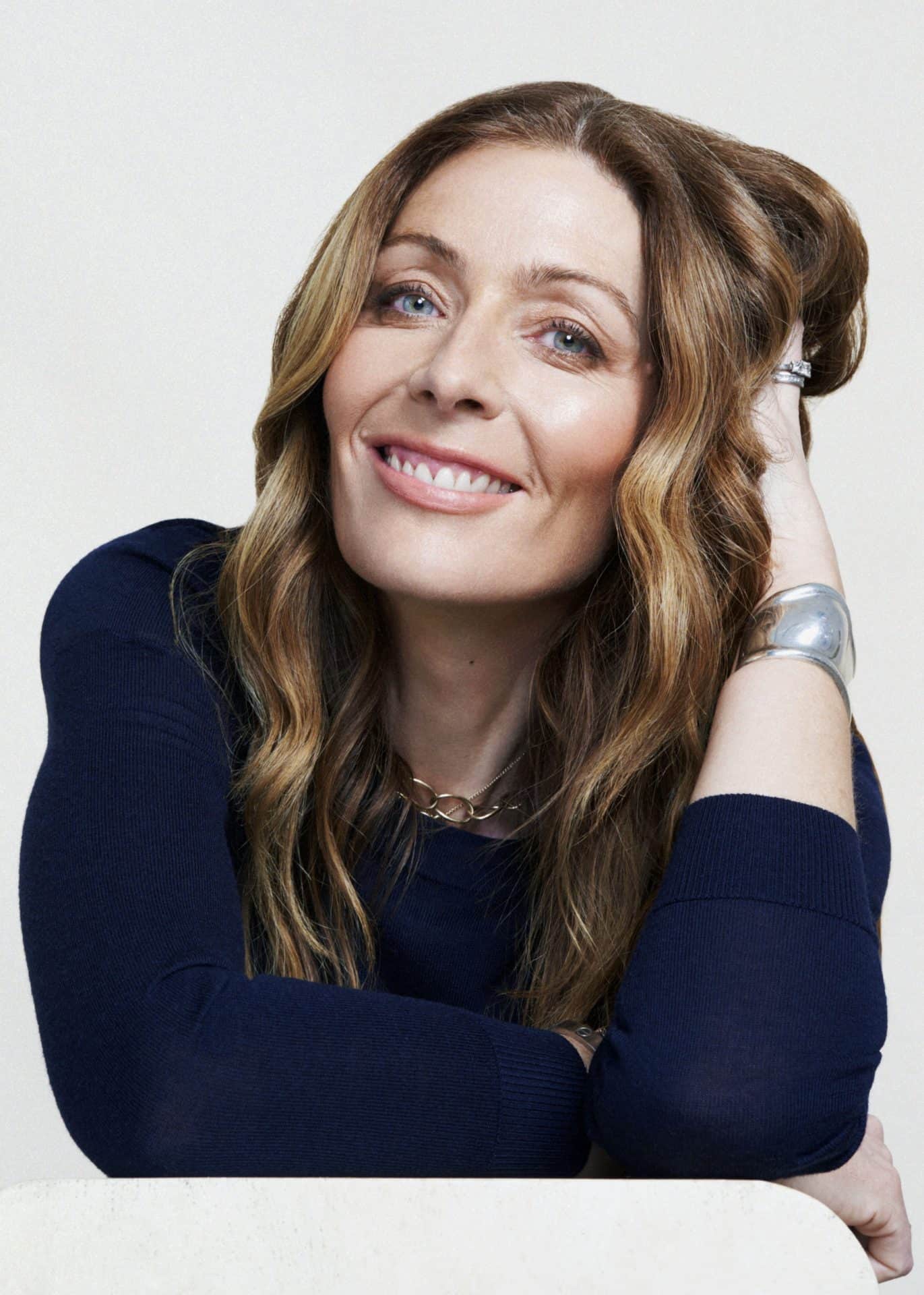 Elegant woman with wavy hair smiling, representing vibrant shopping experience at Victoria Leeds.