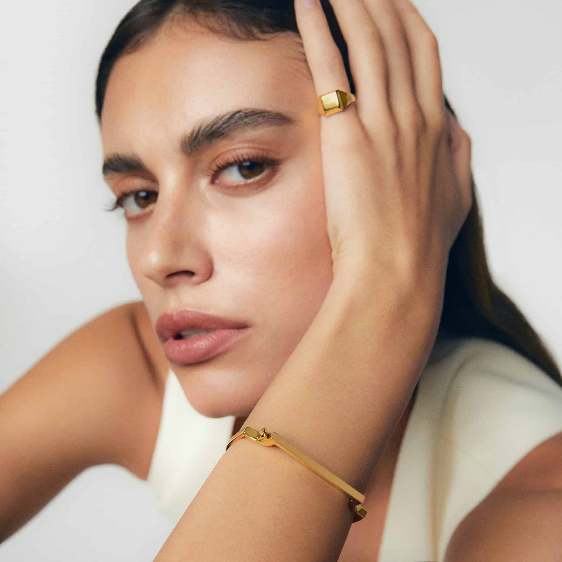 Close-up of a woman wearing gold jewelry, showcasing luxury accessories at Victoria Leeds.