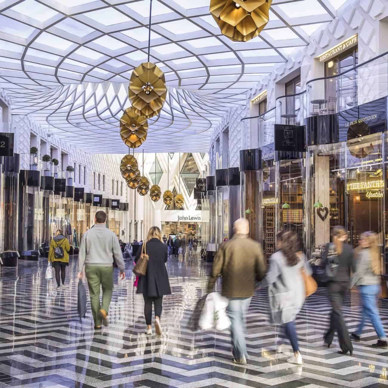 Modern shopping mall interior at Victoria Leeds with shoppers and stylish decor.