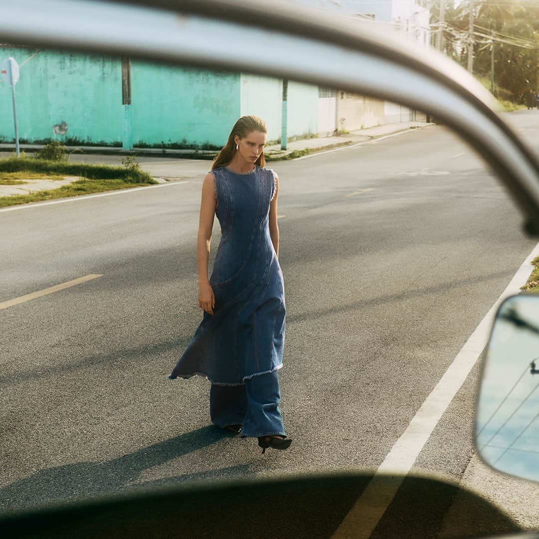 Woman in denim dress walking on street, pre-spring fashion at Victoria Leeds.