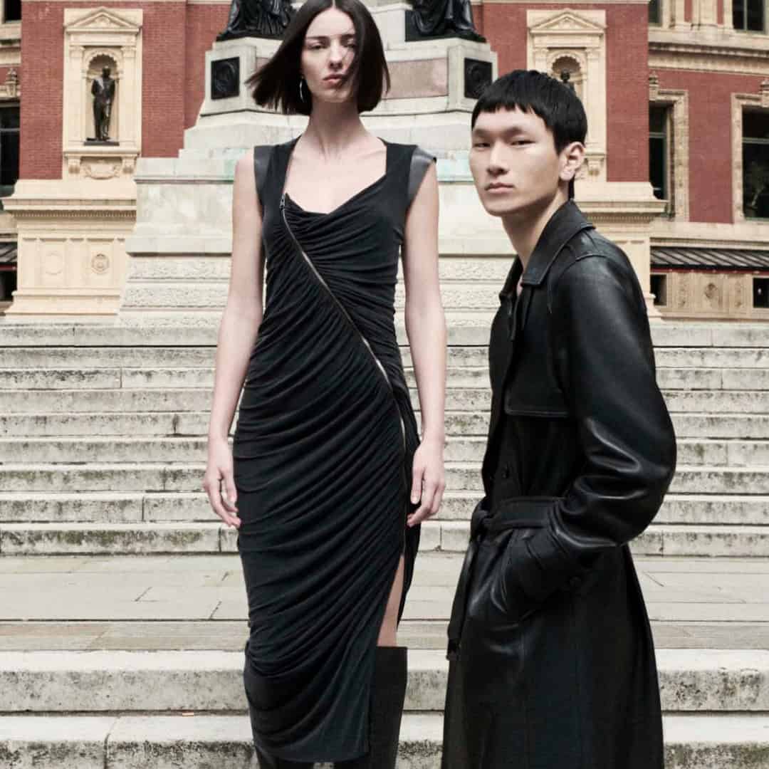 Stylish models showcase autumn 2024 collection outside historic building.