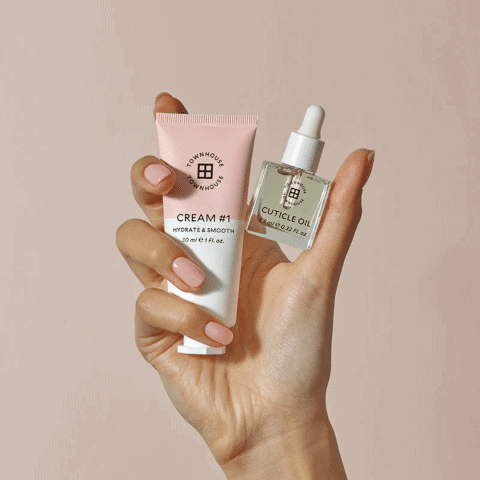 Elegant hand holding skincare products from Victoria Leeds, including a hydrating cream and a cuticl.