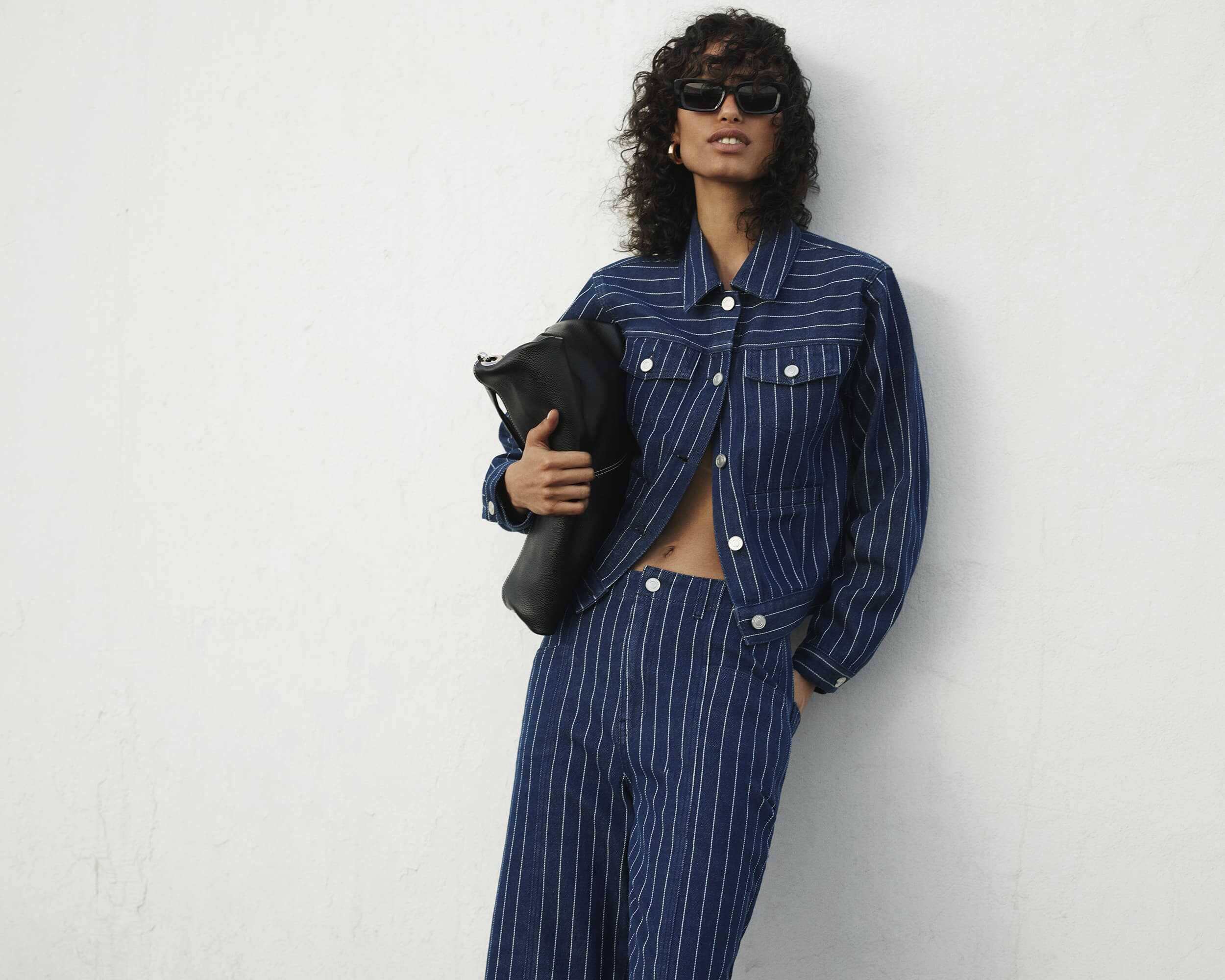 Stylish woman in striped denim outfit for Victoria Leeds SS25 campaign.