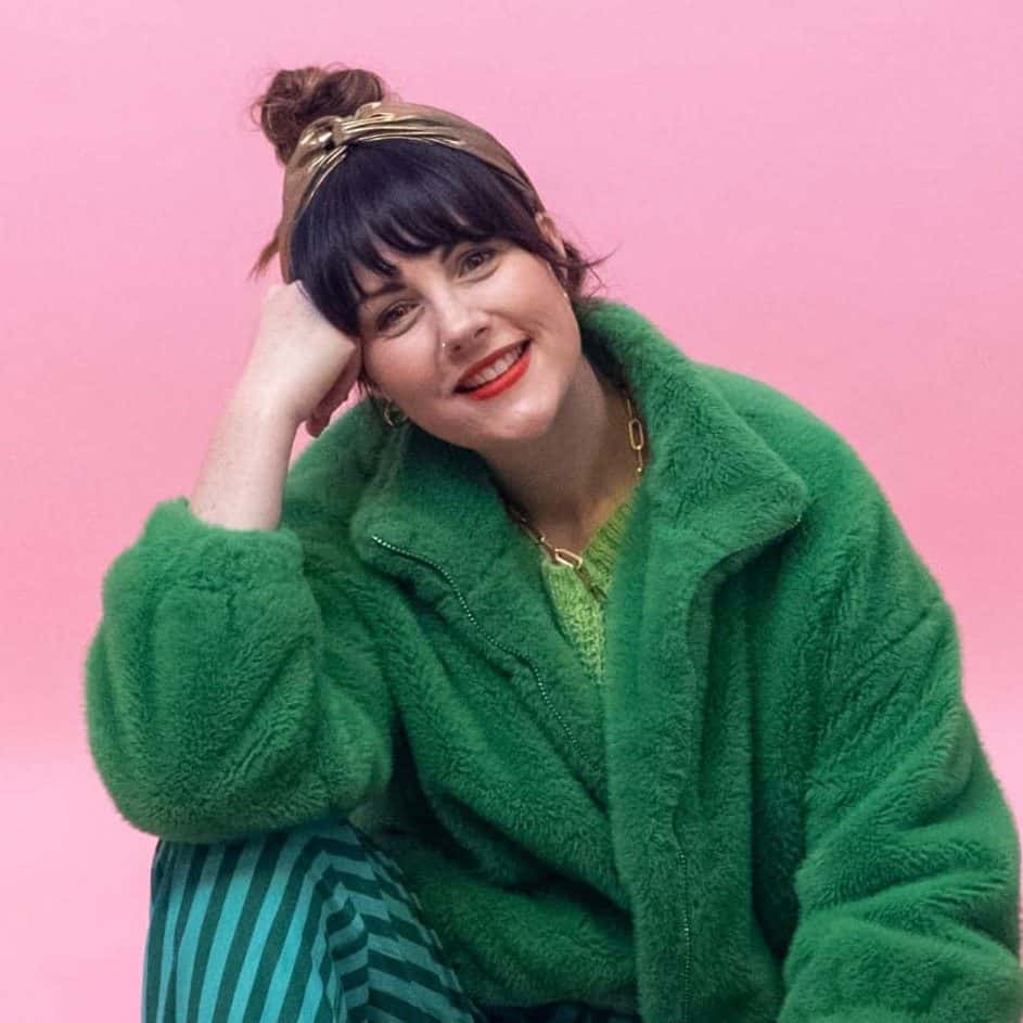 Stylish woman smiling in colorful outfit during Victoria Leeds Fashion Week 2025.