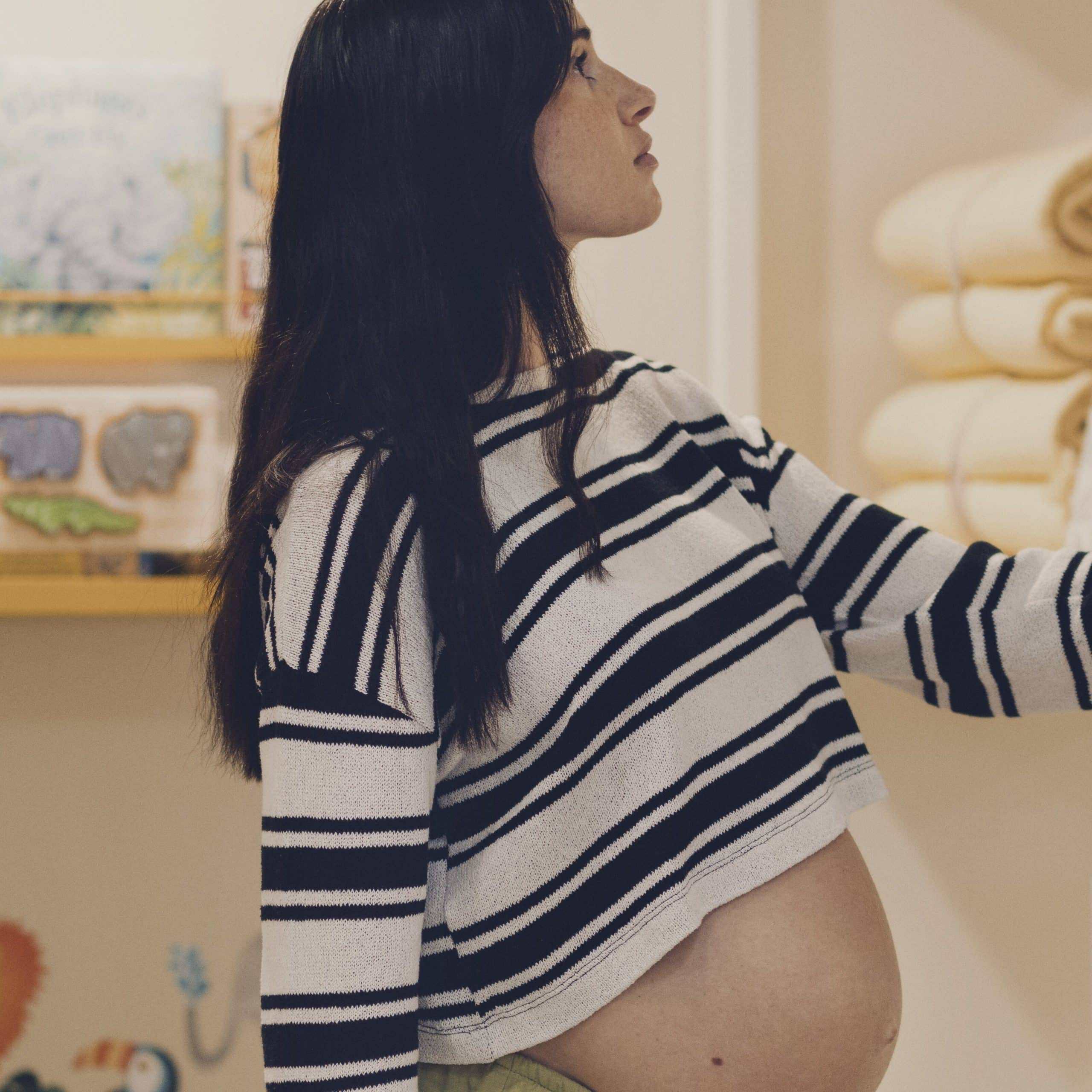 Pregnant woman browsing towels at Victoria Leeds shopping centre, showcasing maternity shopping expe.