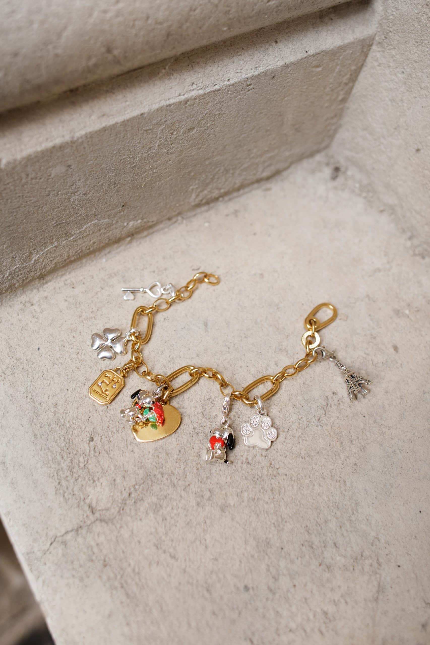 Elegant charm bracelet featuring Peanuts™ characters, perfect for holiday gifting at Victoria Leeds.