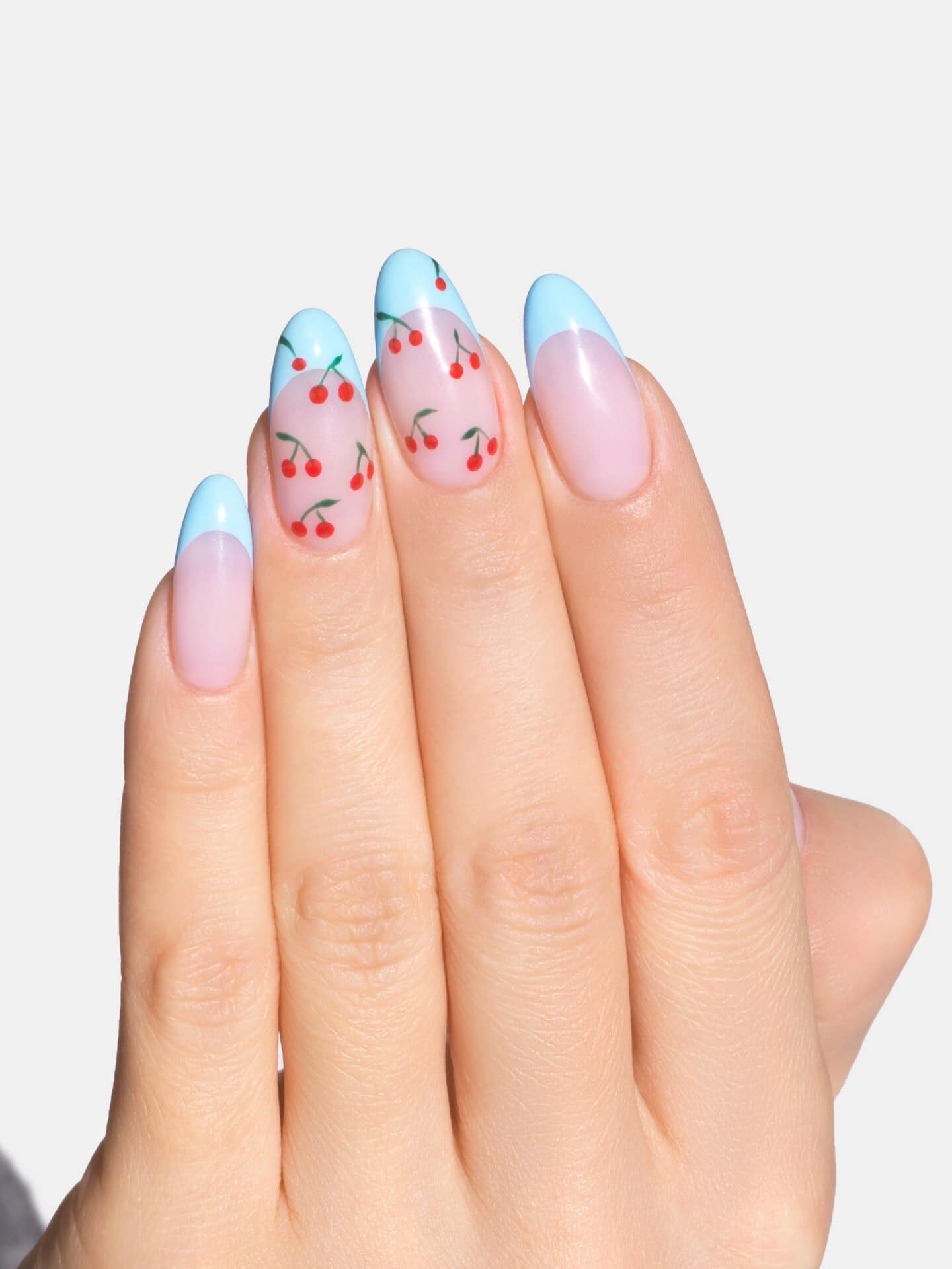 Beautiful cherry-themed nail art with pastel blue tips and cherry designs.