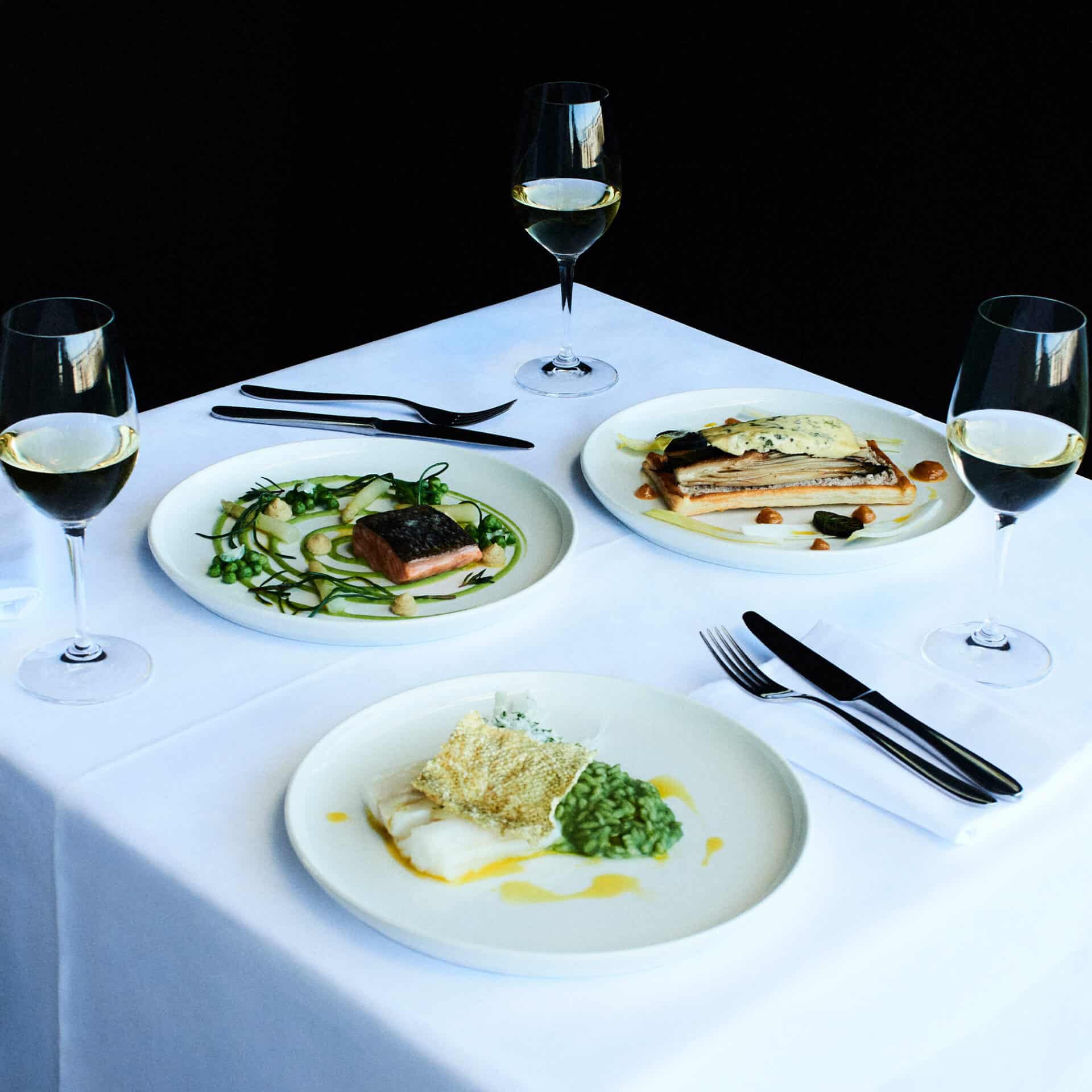 Elegant dining setup with gourmet dishes and wine glasses for Father's Day celebration.