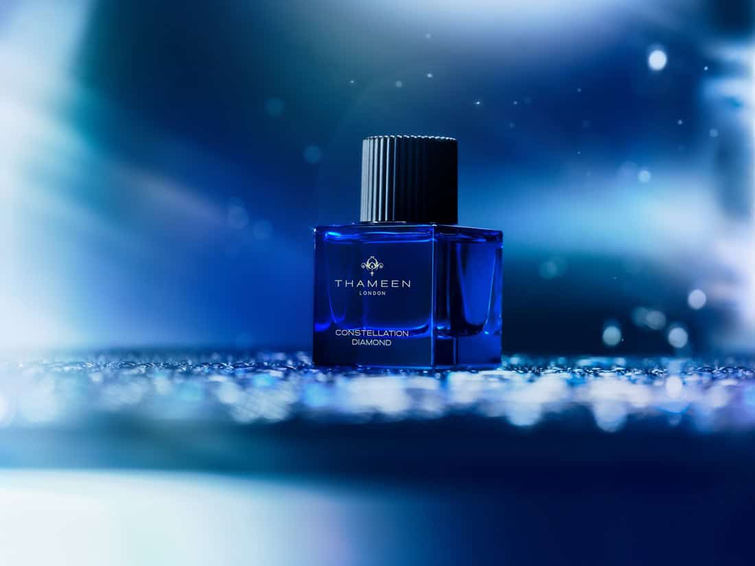 Thameen London Constellation Diamond perfume bottle on a reflective surface with a blue background.
