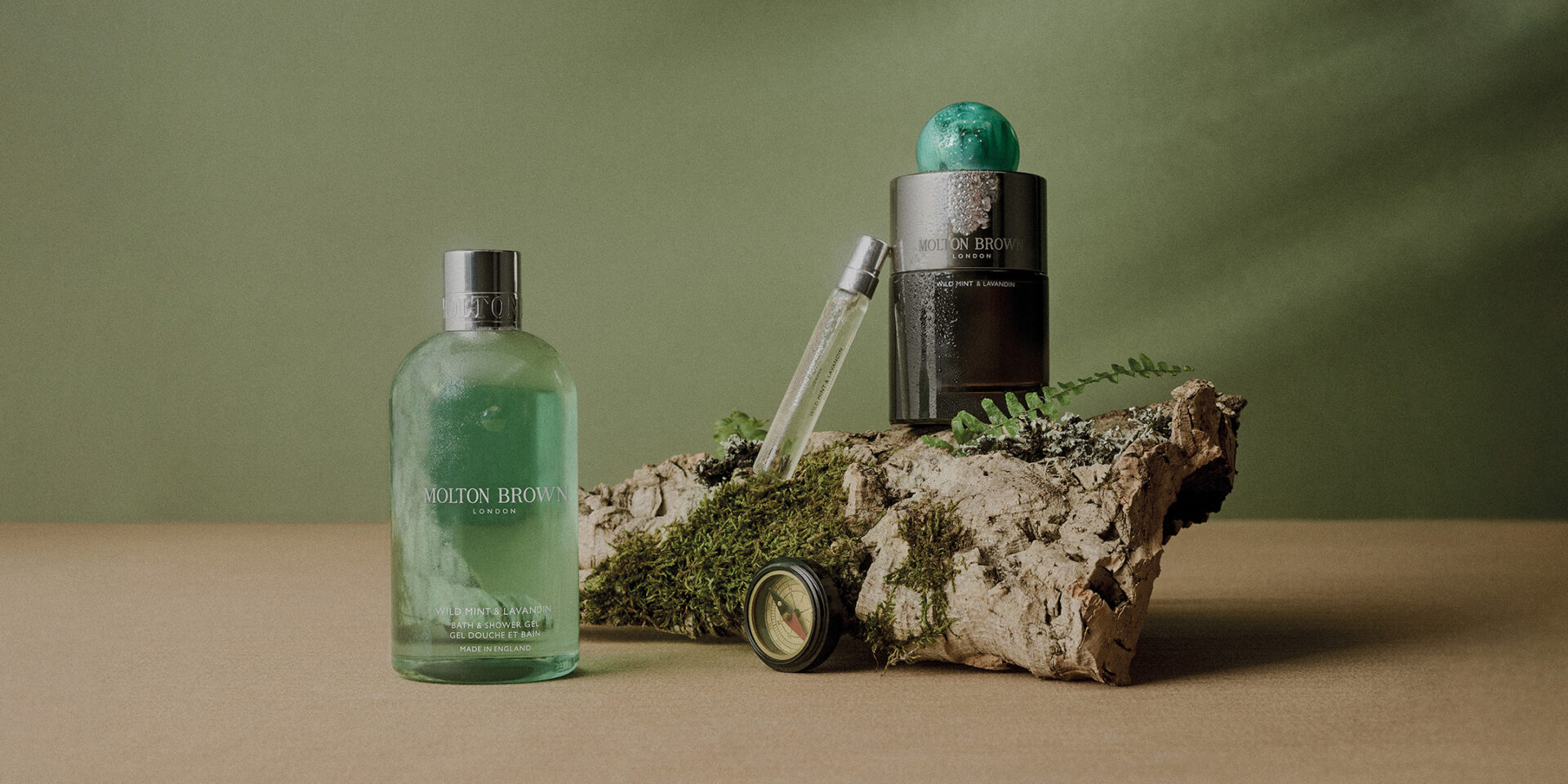 A lush green perfume bottle with natural elements on a textured rock, highlighting luxury and nature.