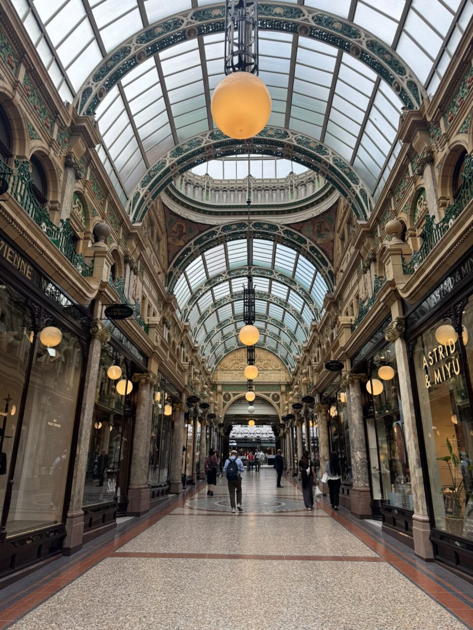 Elegant Victorian-style shopping arcade with glass roof and ornate details.