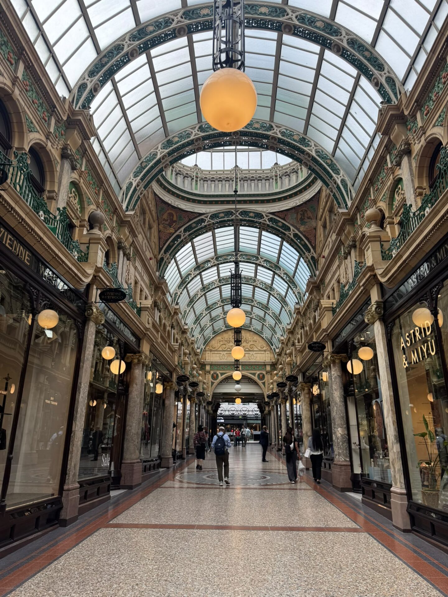 Elegant Victorian-style shopping arcade with glass roof and ornate details.