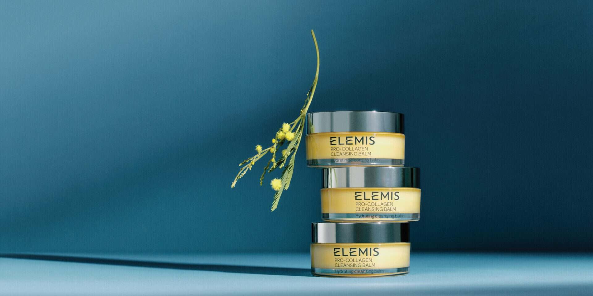 ELEMIS skincare products displayed with a modern blue background.
