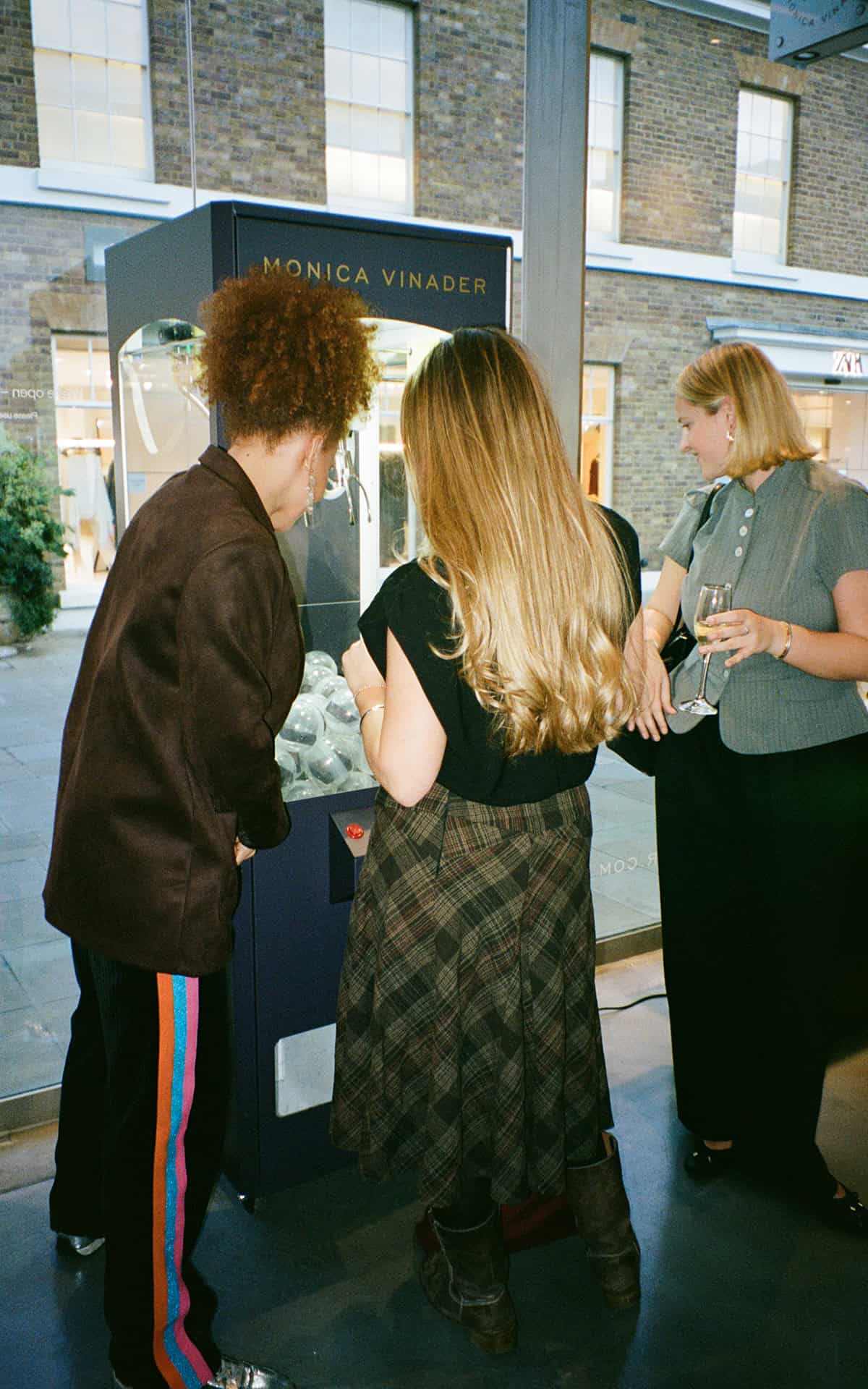 Women playing a Monica Vinader prize game at Victoria Leeds shopping centre.